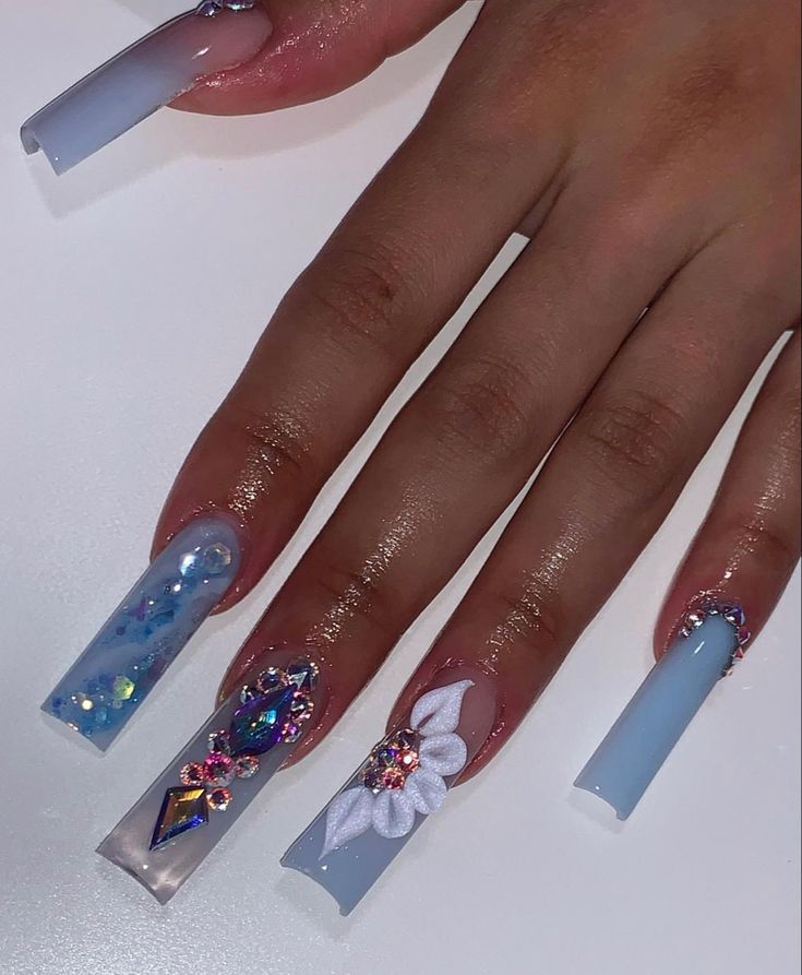 Elegant Vibrant Nail Design with Soft Blue Hues and Intricate Embellishments for Special Occasions.