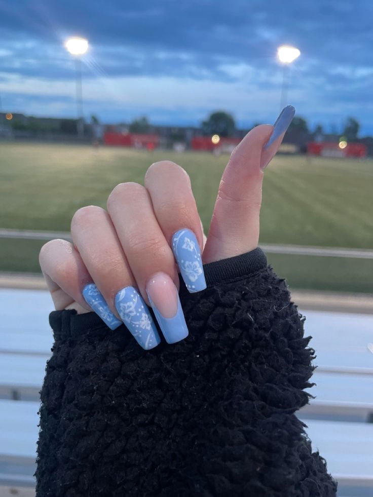 Elegant Soft Blue Floral Nail Design with Glossy and Matte Finishes on Stiletto Shapes.