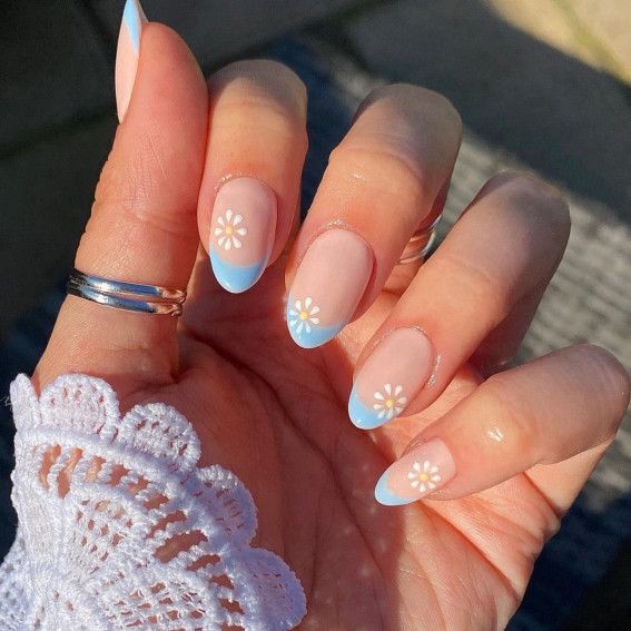 Charming Floral Nail Art: Nude Base with Blue Tips and Whimsical Daisies.