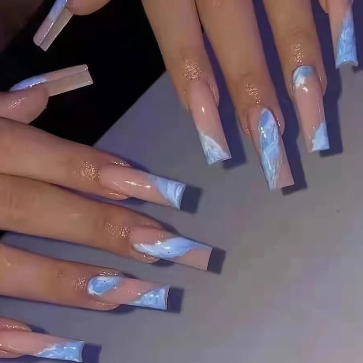 Chic Pastel Blue and Nude Nail Design with Artistic Swirls and Sparkling Accents.