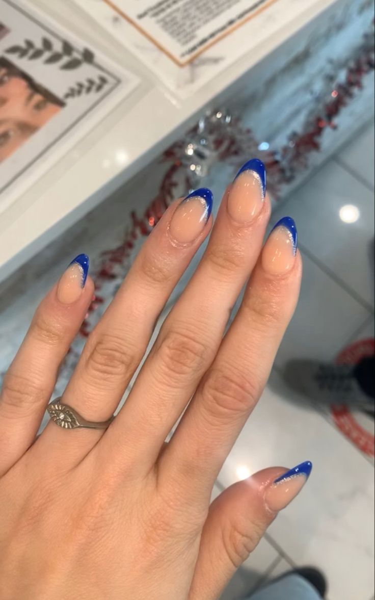 Stunning Almond-Shaped Nails with Vibrant Blue French Tips: A Sophisticated Playful Twist on Classic Design.