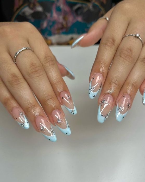 Elegant Nude to Light Blue Gradient Nails with Silver Star Accents.