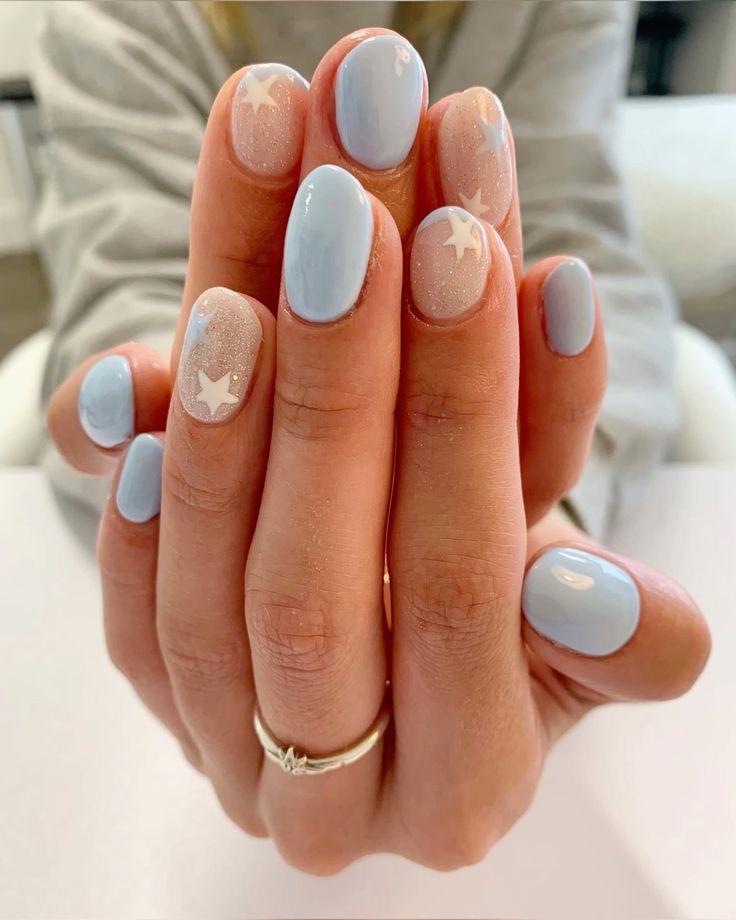 Whimsical Soft Pastel Nail Design with Baby Blue, Nude Shades, and Delicate White Star Motifs.