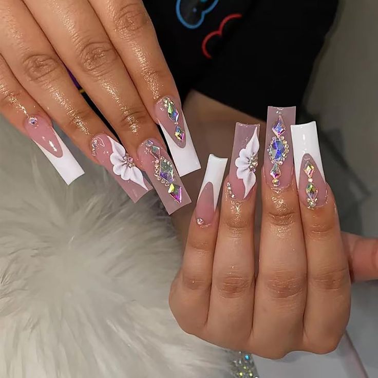 Chic Long Acrylic Nails with Soft Pink and White Hues, Floral Designs, and Sparkling Rhinestones.