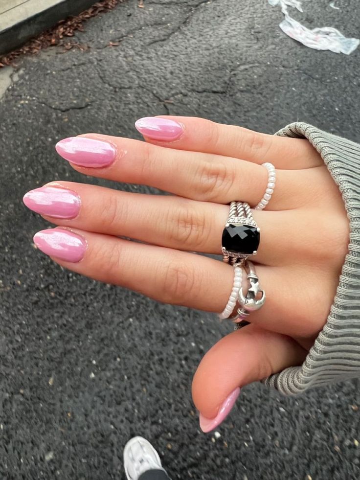 Chic Elegant Pink Almond-Shaped Nail Design with Glossy Finish and Silver Ring Accents.