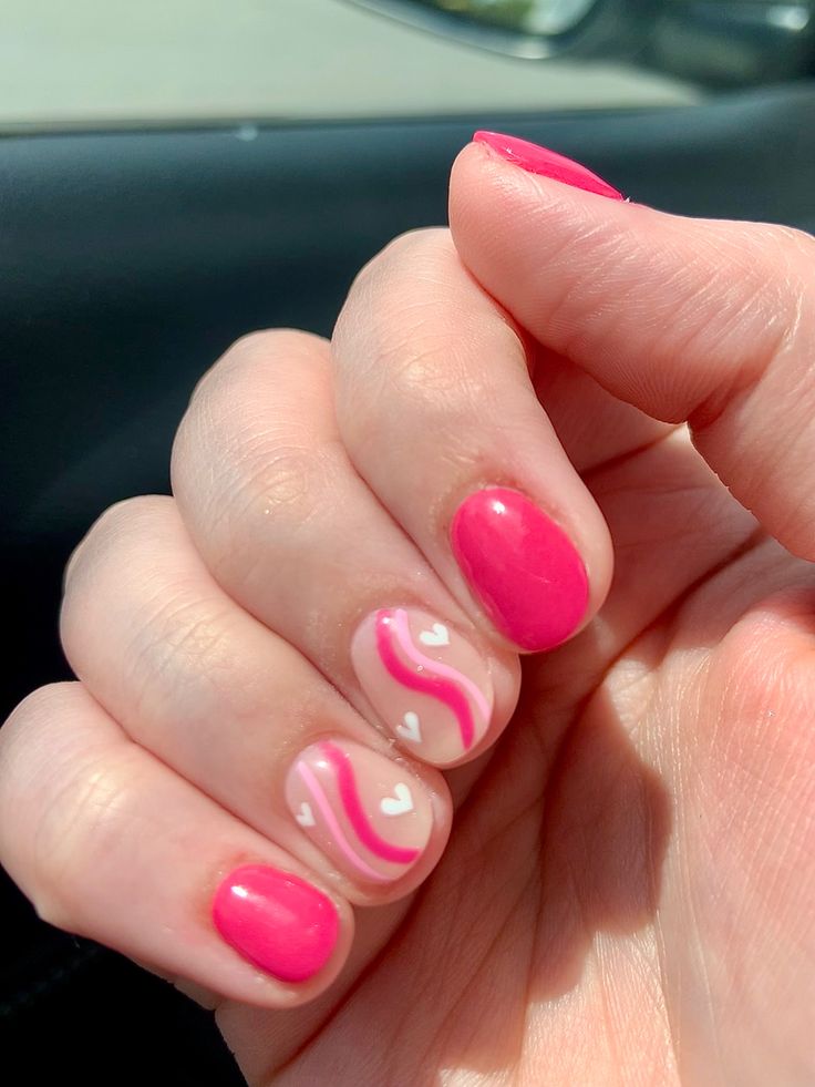 Playful Pink Nail Design with Glossy Shades and Heart Patterns for a Cheerful Aesthetic.