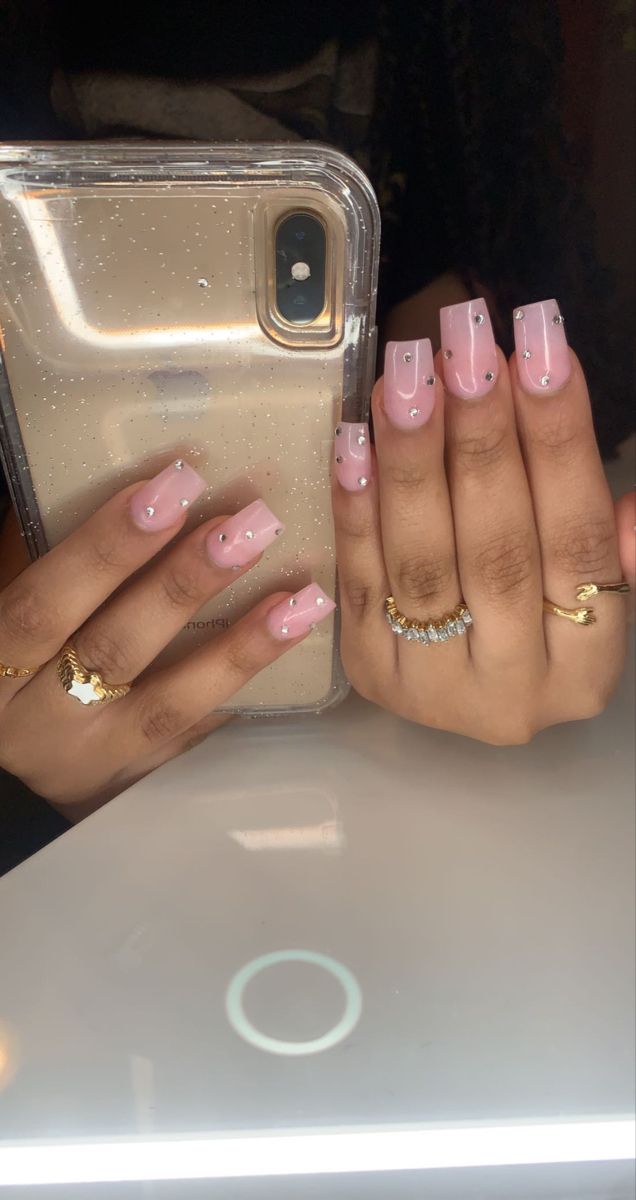 Chic Soft Pink Gradient Nail Design Enhanced with Gemstones and Golden Rings.