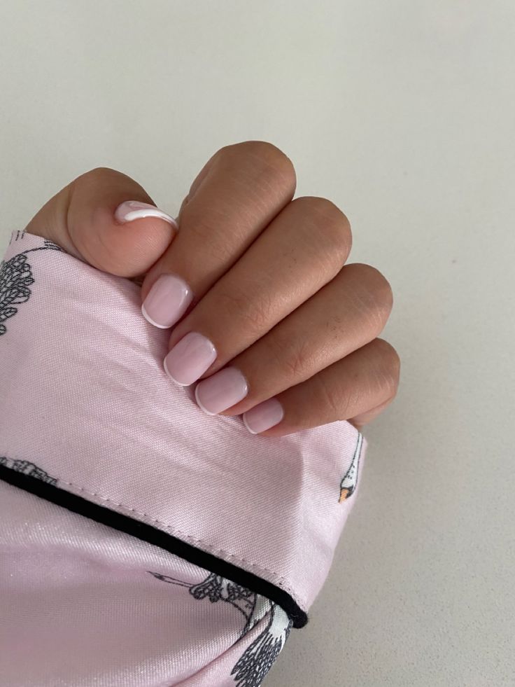 Chic Soft Pink Manicure with Elegant White Accents and Trendy Fabric Pairing.