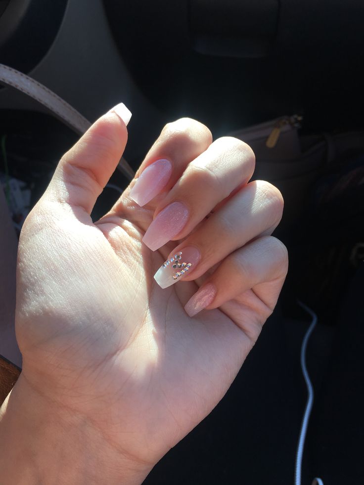 Sophisticated Elongated Nail Design with Soft Pink, Classic White Tips, and Glamorous Embellishments.