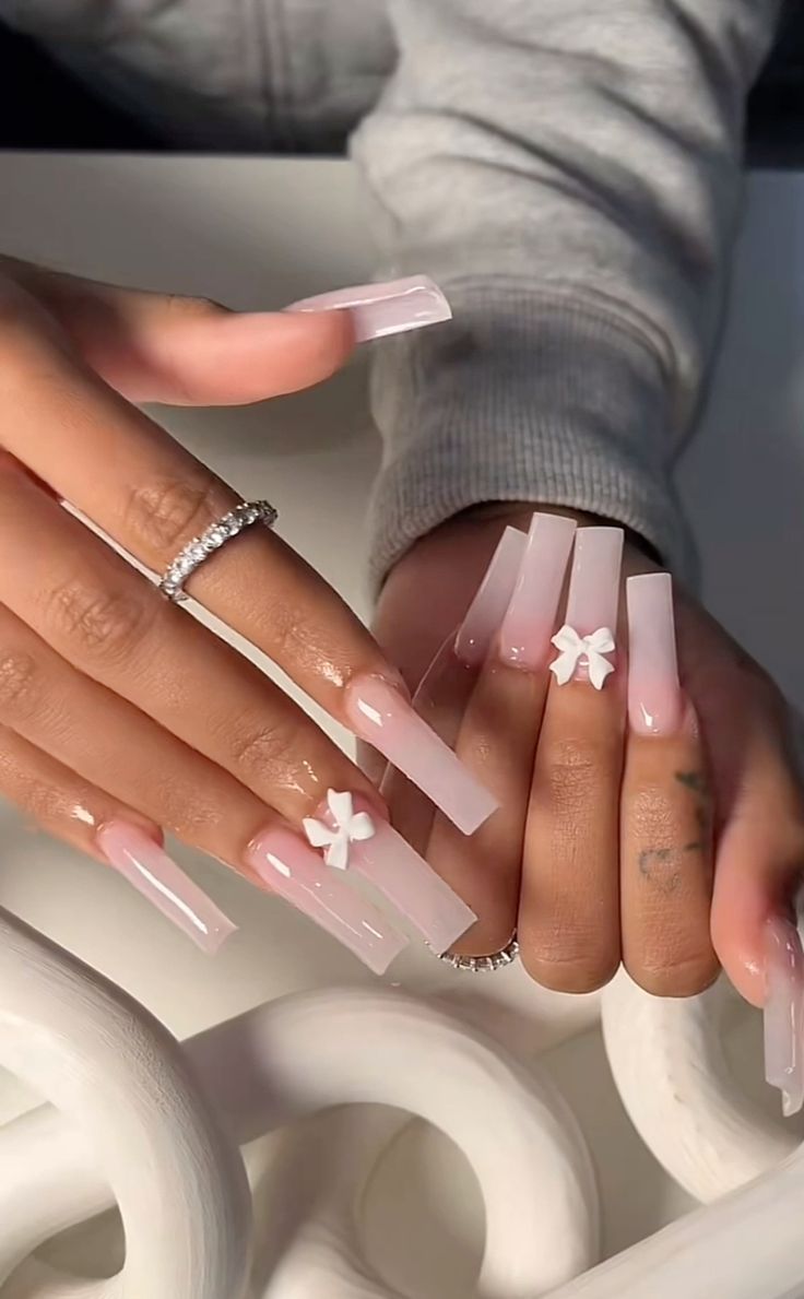 Chic Elegant Nail Design with Translucent Pink Tips and Delicate White Flower Charms