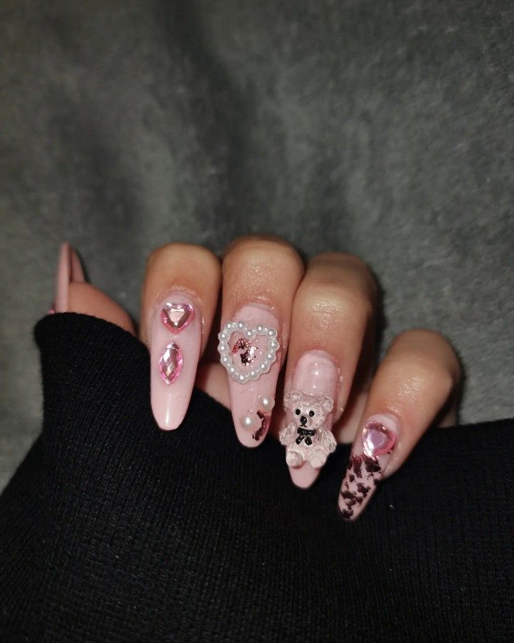 Charming Soft Pink Nail Design with Playful Teddy Bear Accents and Elegant Embellishments.