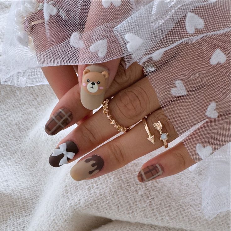 Charming Playful Nail Design with Bear and Chocolate Motifs in Warm Colors.