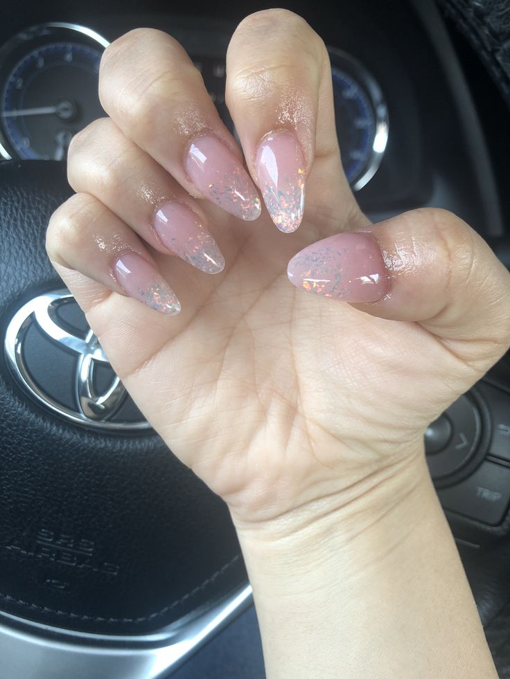 Elegant Almond-Shaped Nails with Soft Pink Gradient and Shimmering Glitter Accents.