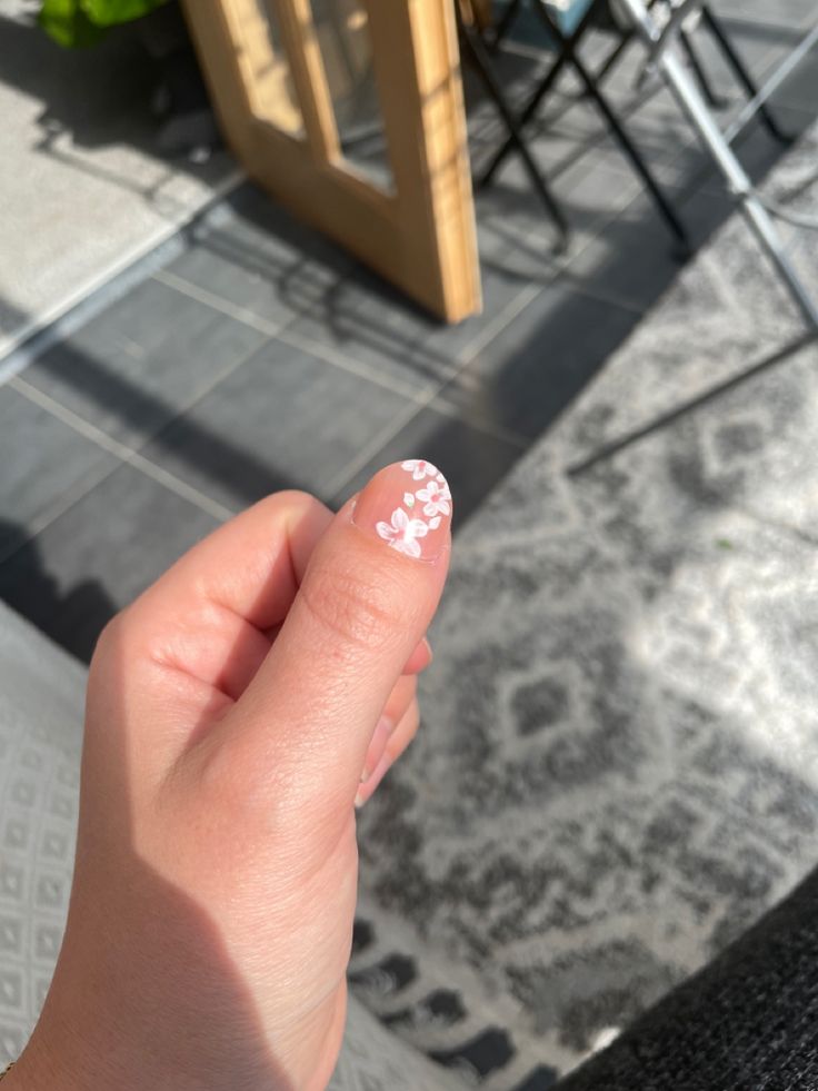 Charming Pink Nail Art with White Floral Patterns: A Delicate Spring Elegance.