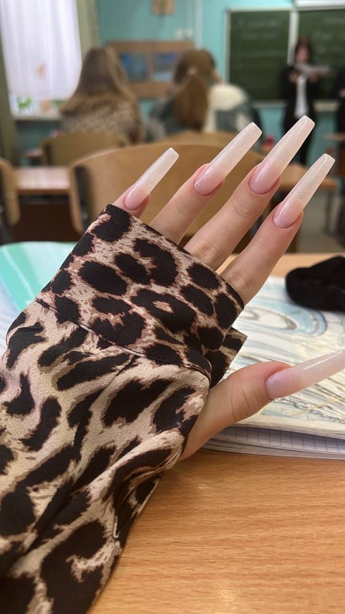 Chic Nail Design with Nude Sheen and Bold Leopard-Print Sleeve Contrasts.