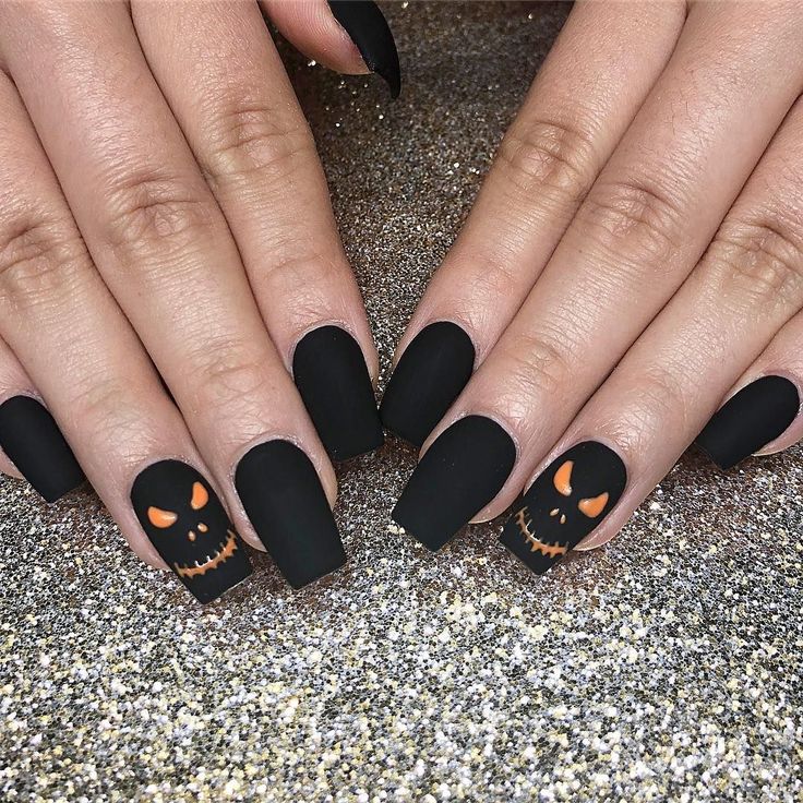 Bold Halloween Nail Design: Matte Black with Playful Pumpkin and Skull Accents.