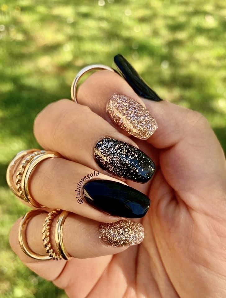 Elegant Nail Design: Glossy Black with Glittering Gold and Rose Tips.