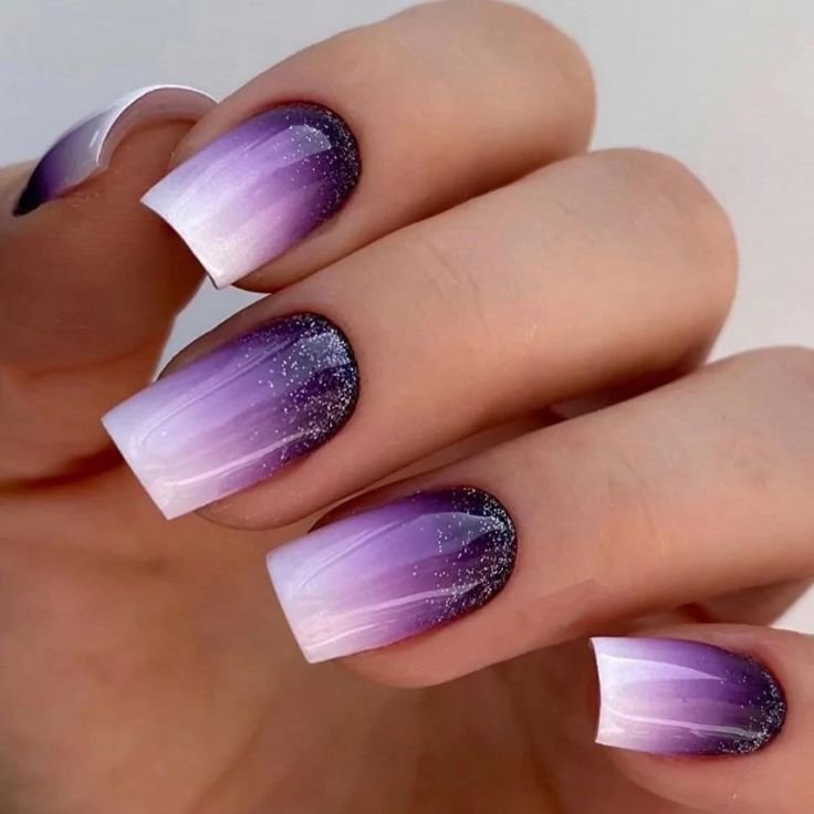 Elegant Ombre Nail Design: Purple to White Gradient with Sparkling Accents.