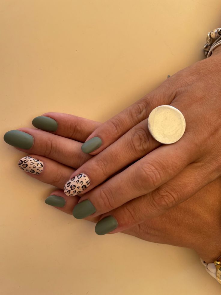 Elegant Matte Green Nails with Playful Leopard Print Accent.