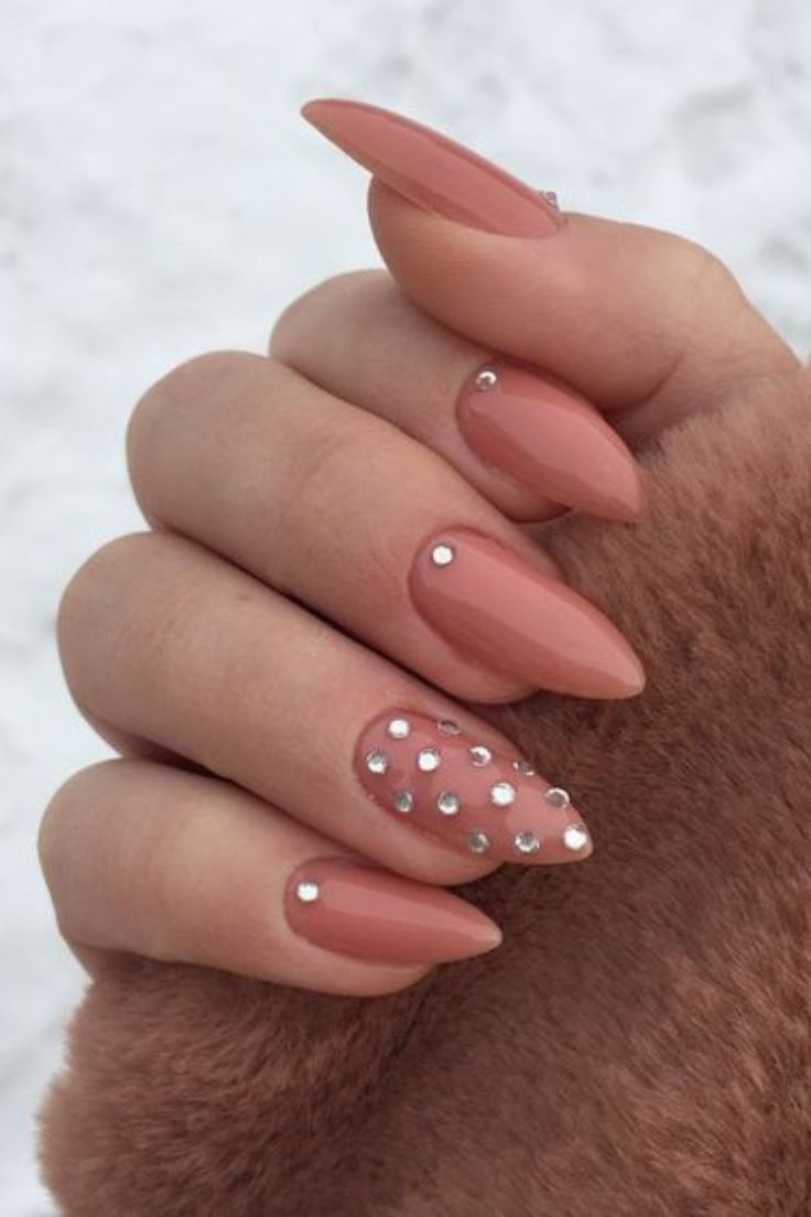 Elegant Nude Almond-Shaped Nails with Glamorous Rhinestone Accent.