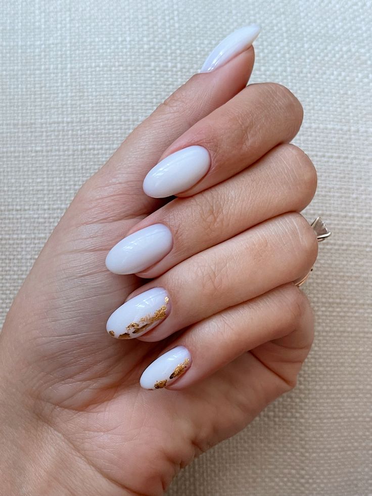 Sophisticated Almond-Shaped Nails with Smooth White Finish and Elegant Golden Accents.