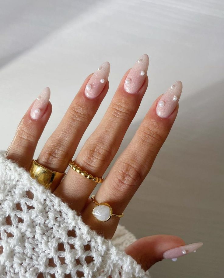 Elegant Almond-Shaped Nails with Gradient Pink and Nude Base, Accented by White Dots and Minimalist Gold Rings.