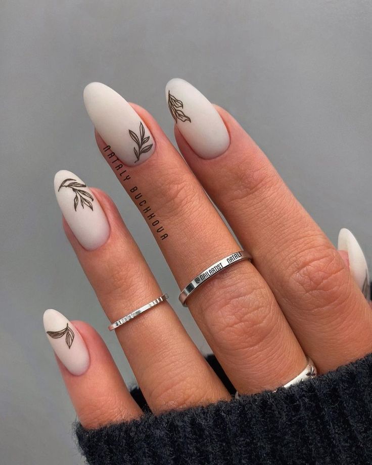 Chic Matte Nude Nails with Botanical Designs and Silver Accents