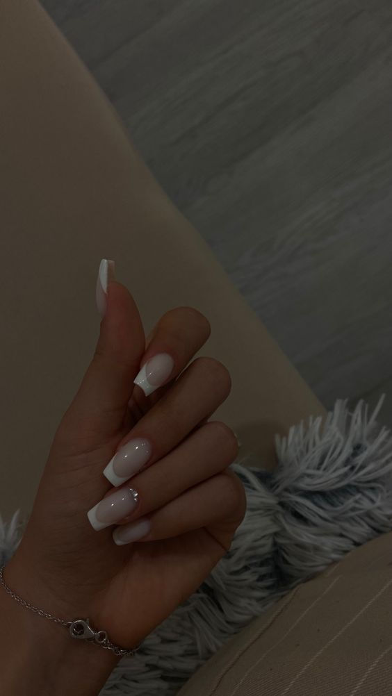 Sophisticated French Manicure with Glamorous Shimmer: A Timeless Elegance for Any Occasion.