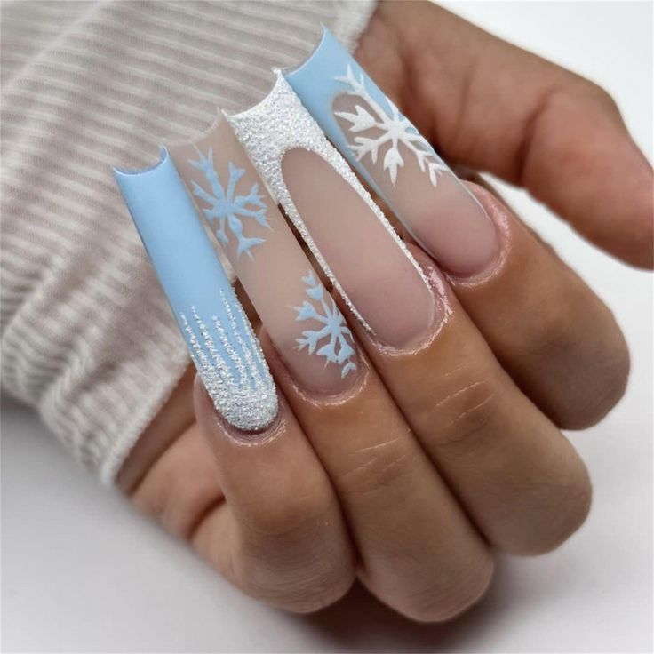 Elegant Winter Nail Design: Soft Blue Elongated Tips with Delicate Snowflake Patterns.