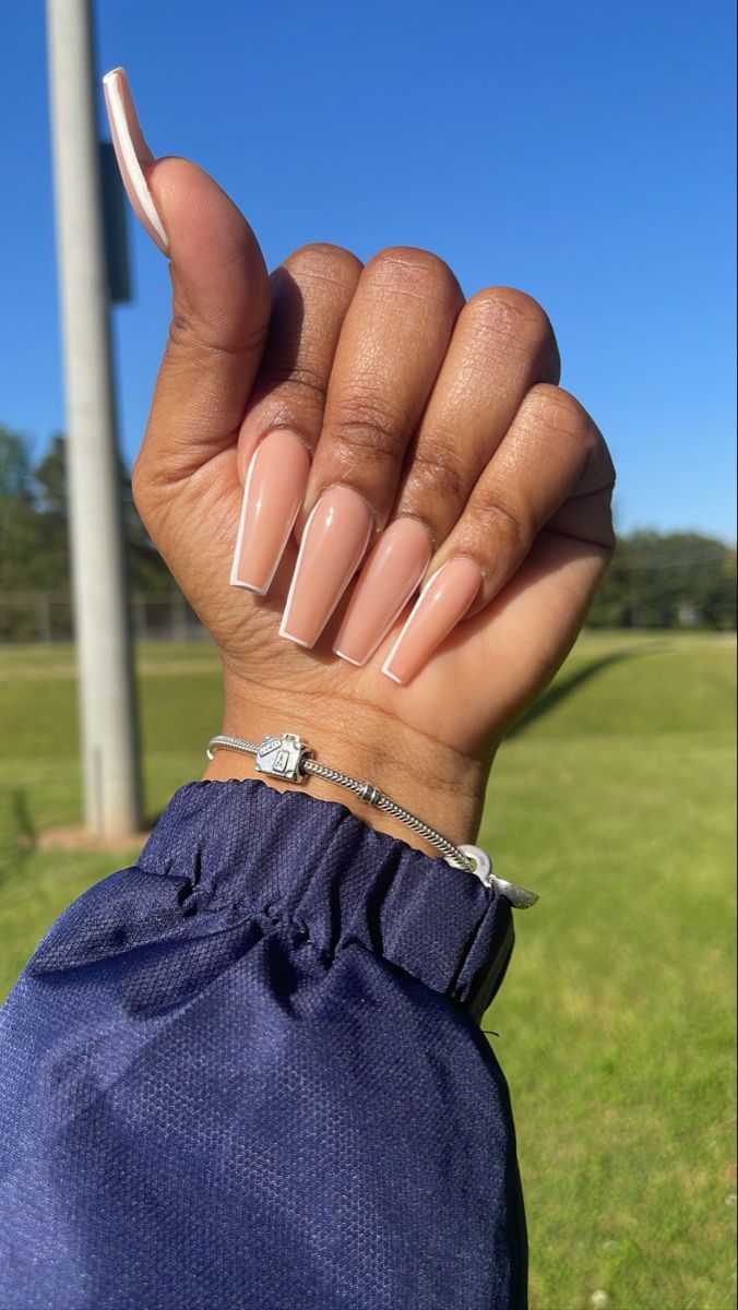 Chic Long Nude Nails with Glossy Finish and Elegant Jewelry Accents.