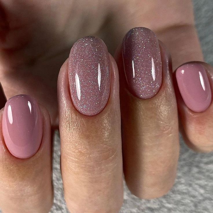 Sophisticated Soft Pink Nail Design with Glittery Accents and Gradient Finish.