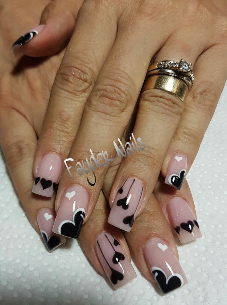 Charming Nail Design: Soft Pink and Elegant Black Accents with Intricate Heart Shapes