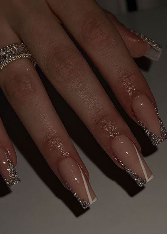 Sophisticated Nude Nail Design with Sparkling Silver Tips and Glamorous Rhinestones.