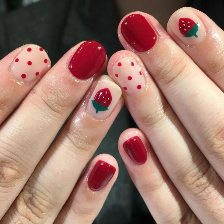 Whimsical Strawberry-Inspired Nail Design with Playful Colors and Patterns for Summer.