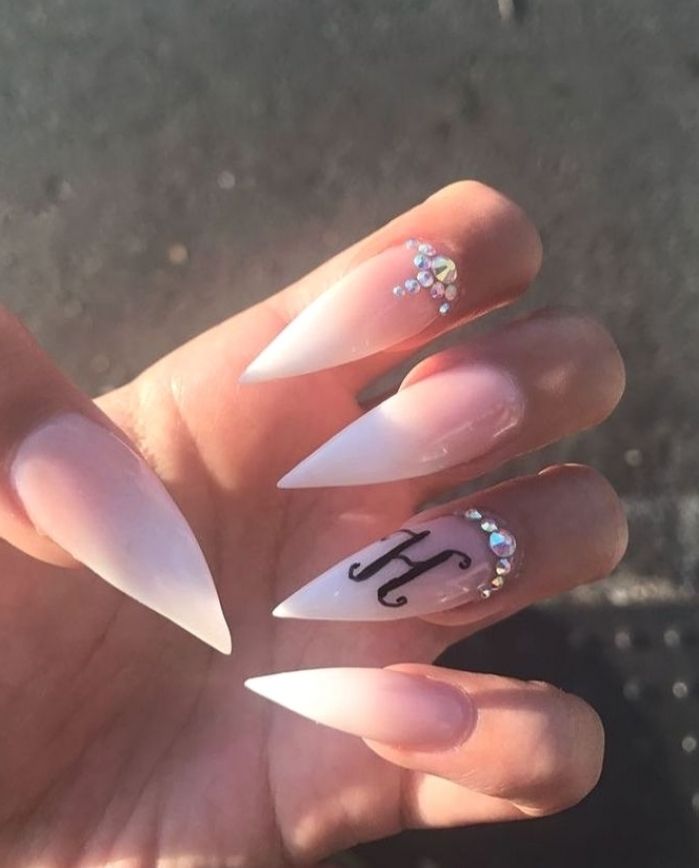 Elegant Stiletto Nails with Ombre, Rhinestones, and Personalized Letter Detail.