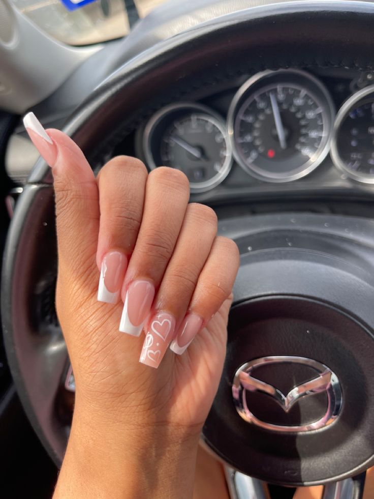 Chic French Manicure: Elegant Tapered Tips, Soft Nude Base, and Playful Heart Detail.