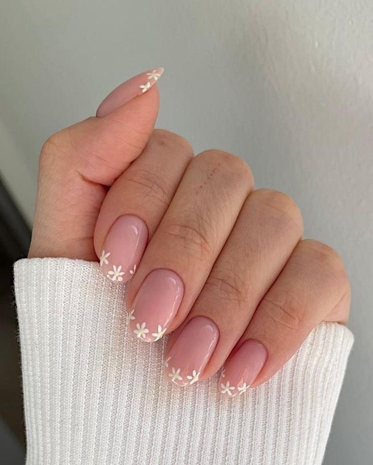 Charming Spring-Inspired Floral Nail Design with Soft Pink Base and White Accents.