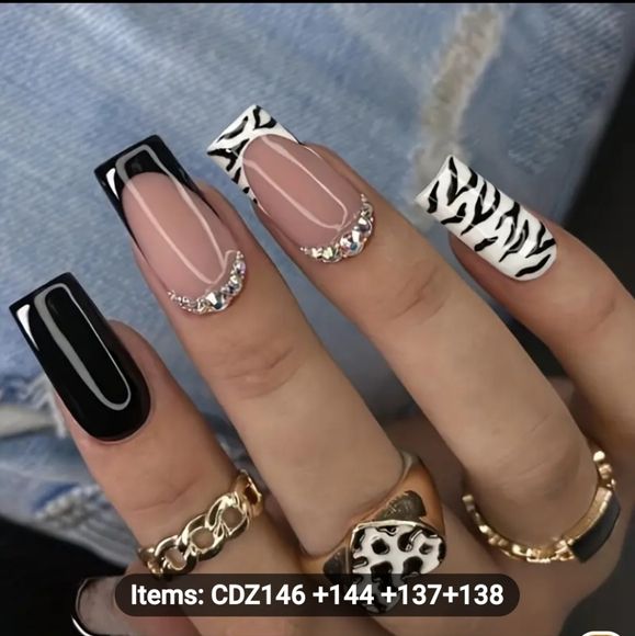 Chic Nail Design: Bold Zebra Patterns and Elegant Rhinestones on a Nude Base.