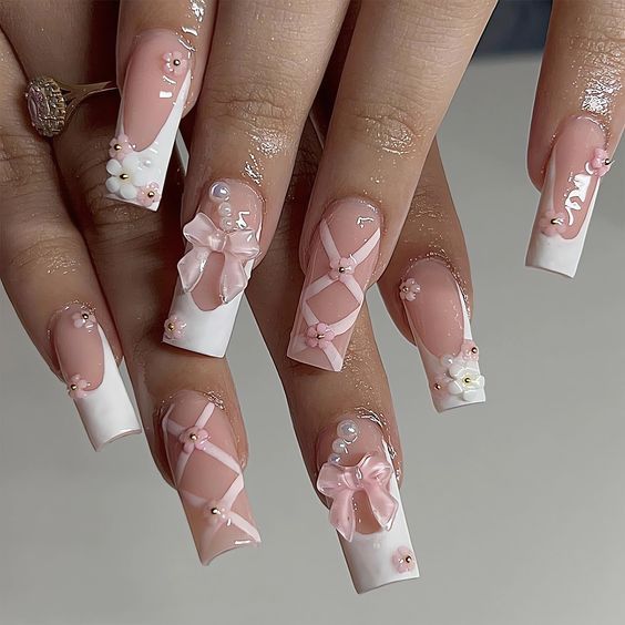 Chic Nude and White Nail Design with Pink Bows, Floral Accents, and Pearl Details.