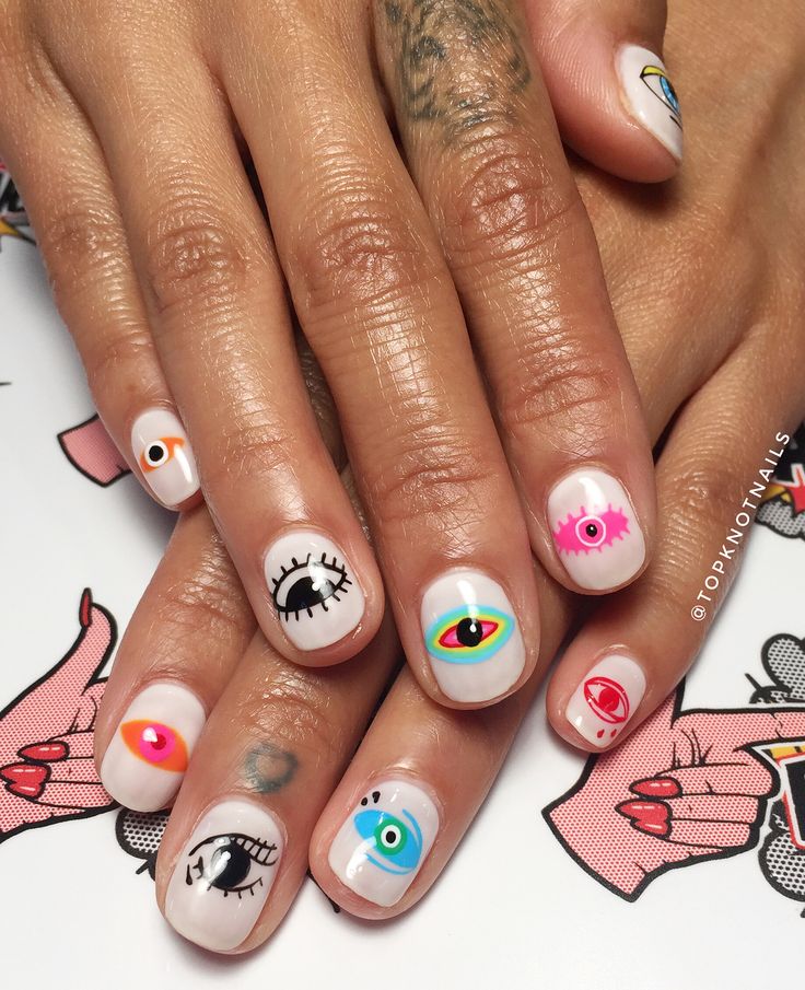 Playful Whimsical Nail Designs with Colorful Eye Motifs and Striking Patterns.