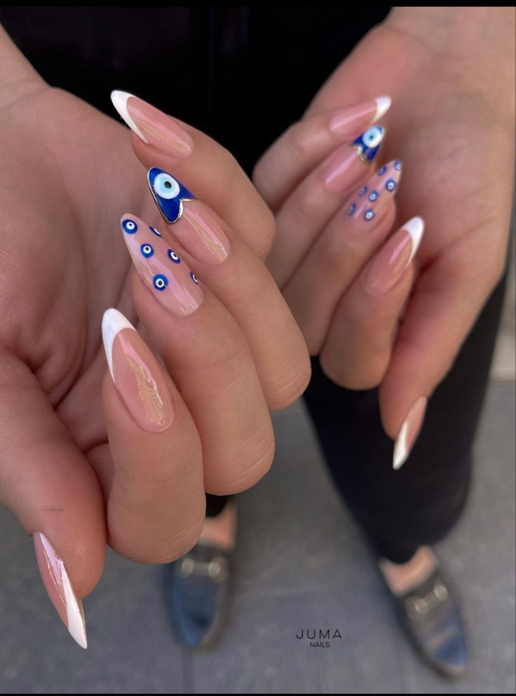 Modern French Manicure: Bold Blue and White Eye Motifs on Nude Nails.