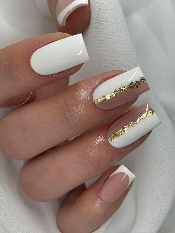 Sophisticated Nail Design: White and Nude Tones with Glamorous Golden Accents.