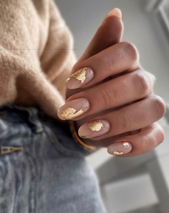 Sophisticated Nude Nail Design with Delicate Gold Leaf Accents.