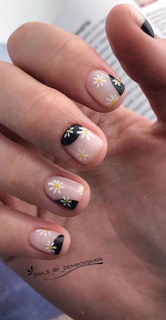 Whimsical Nail Design with Neutral and Black Hues Featuring Delicate Daisies and Asymmetrical Tips.