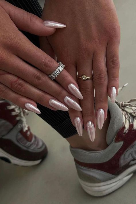 Chic Almond-Shaped Nails and Delicate Rings Contrast Elegantly with Casual Sneakers.