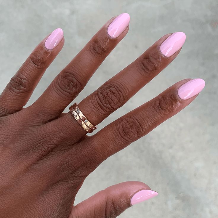 Chic Almond-Shaped Pink Manicure with Gold Ring Accents