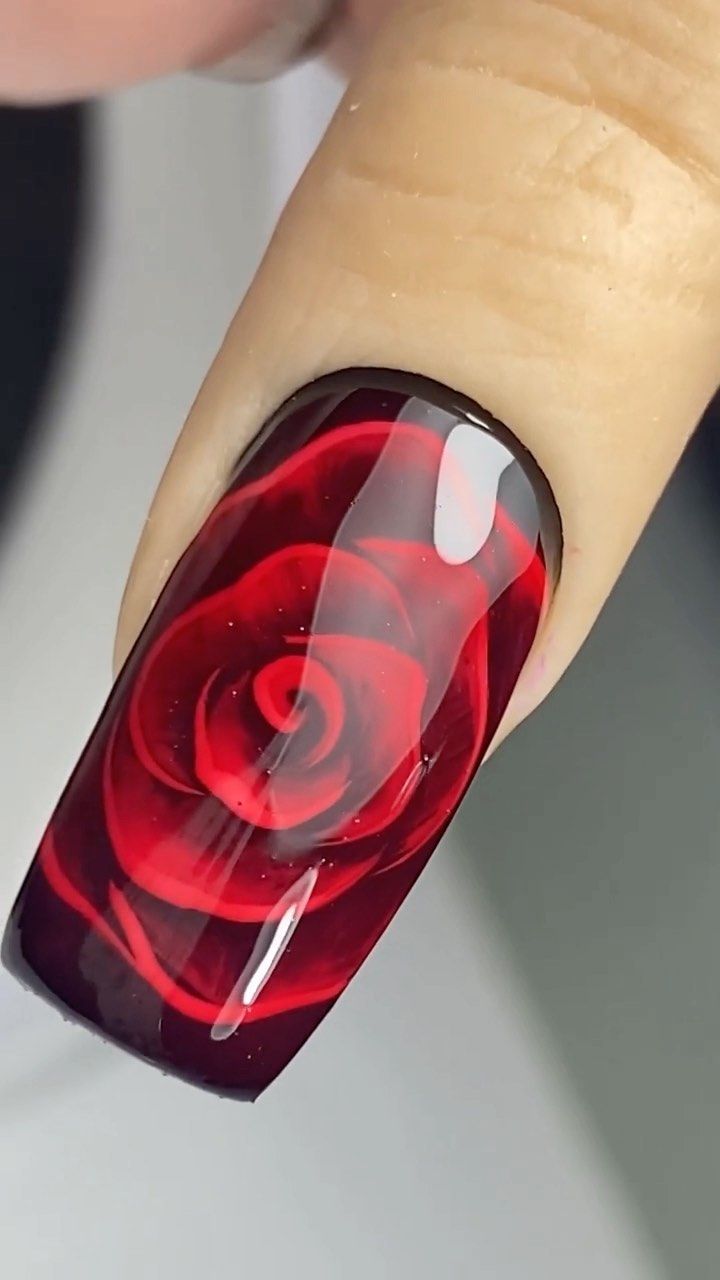 Elegant Red Rose Nail Art: Striking Design on Glossy Black Background for Romantic Occasions.