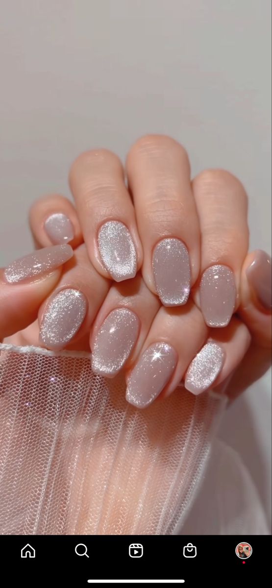 Elegant Glittery Nail Design with Nude Base and Silver Gradient Accents.