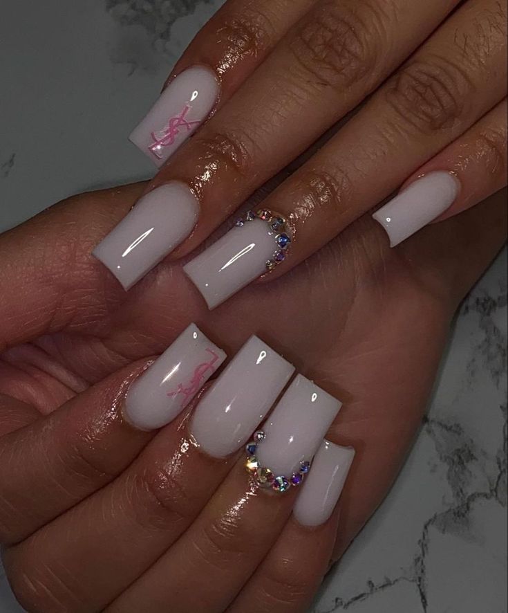 Sophisticated Nail Design with Glossy White Base, Delicate Pink Accents, and Sparkling Rhinestones.