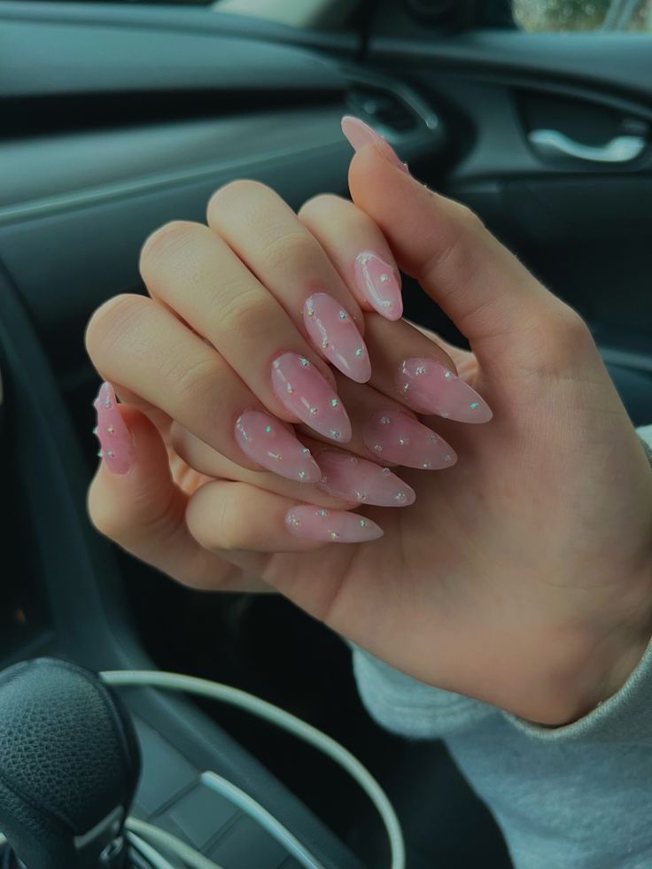 Glamorous Stiletto Nails: Soft Pink Elegance with Sparkling Embellishments.